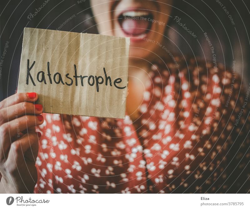 Young woman holds a sign that says "disaster" and screams cataclysm Horror peril Fear Accident news bad news Woman Scream Panic Distress Criticism Emergency