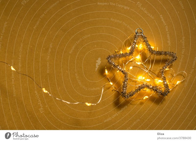 Poinsettia with glowing fairy lights on a yellow background. Christmas. Stars Christmas star Fairy lights Illuminate Advent Yellow Christmas decoration