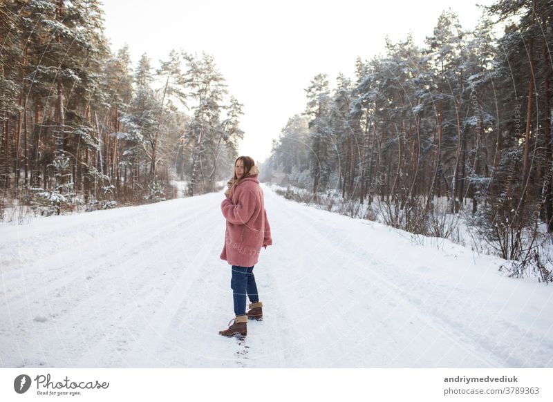 Young pretty stylish woman having fun in the winter snowy forest in motion. girl model happiness smile portrait adult attractive background beautiful beauty