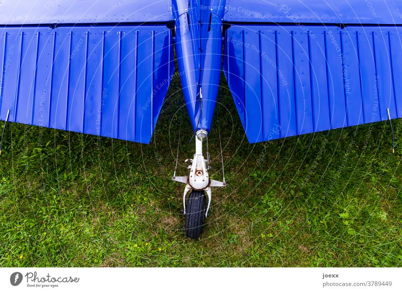 Elevator of a propeller aircraft with tail wheel landing gear elevator Wheel Rear wheel Airplane Blue Green Aviation Rear wing rudder Landing gear Meadow Lawn