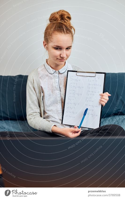 Student learning online, watching lesson remotely, listening to professor, talking with classmates on video call from home during quarantine accessories bed