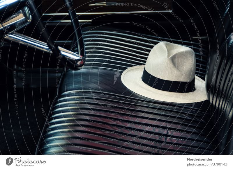 Noble hat on a leather bench in an oldtimer car Vintage car Seat Hat Leather oldie Old vintage close up Metal technique schearz automobile Steering wheel