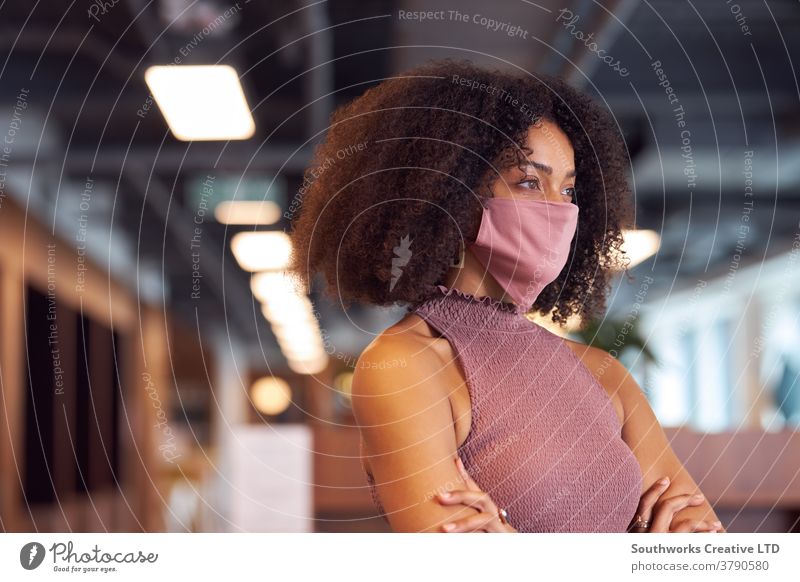 Businesswoman Wearing Face Mask In Modern Open Plan Office During Covid-19 Pandemic business businesswoman face mask face covering ppe wearing office worker