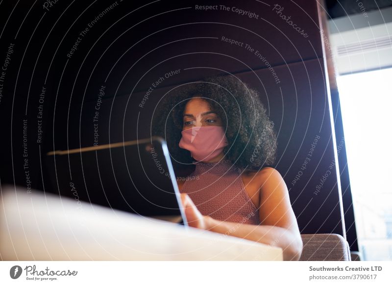 Businesswoman Wearing Mask Working In Socially Distanced Cubicle In Office During Health Pandemic business businesswoman face mask face covering ppe office