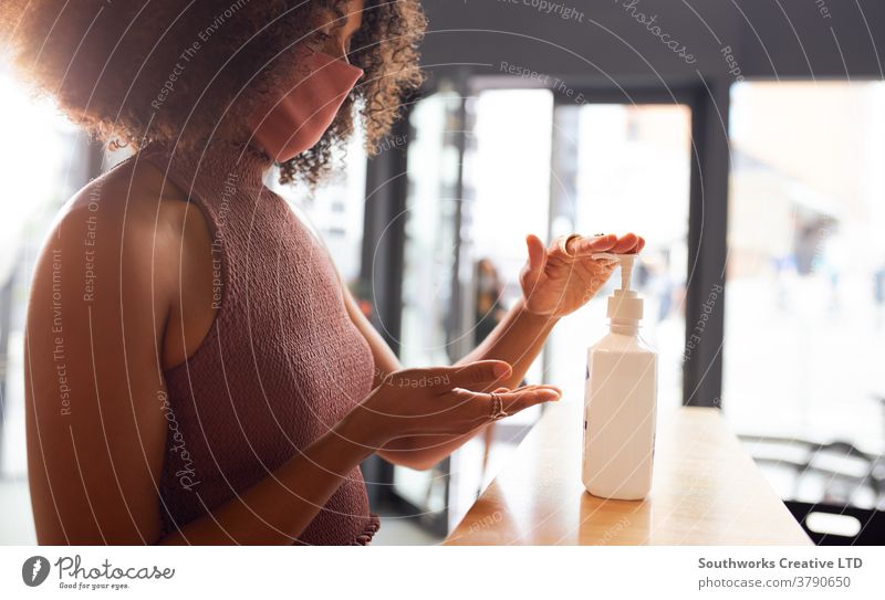 Businesswoman using hand sanitizer before entering office female employee gel sanitiser dispenser business businesswoman 20's millennial twenties young adult