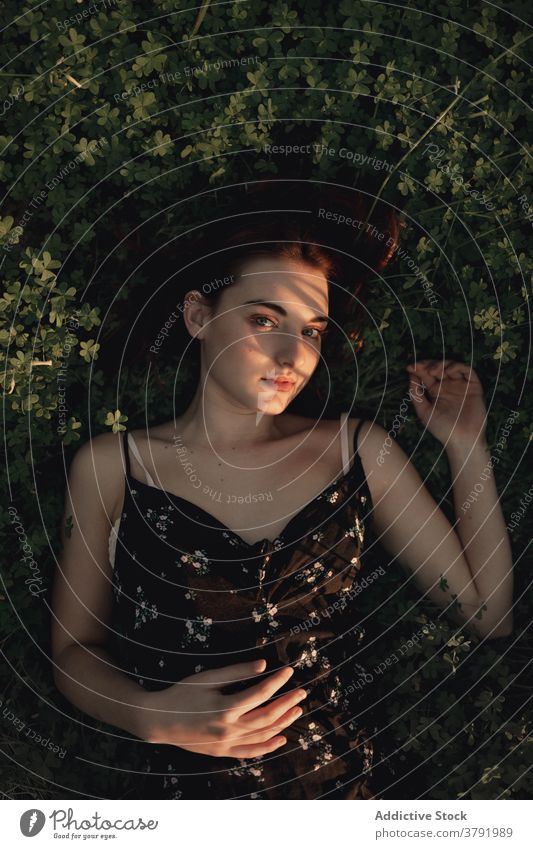 Tranquil woman lying on grass in park enjoy sun relax tranquil tender delicate female iceland lush lawn dress summer serene freedom harmony green rest calm