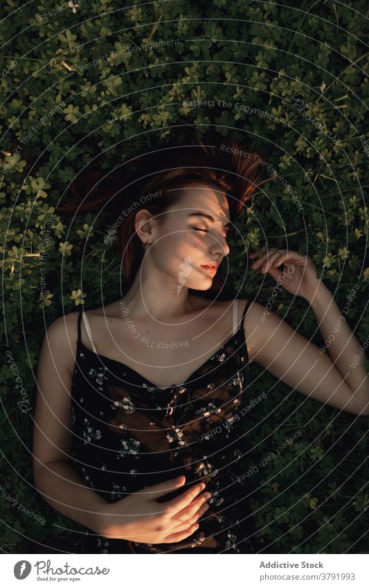 Tranquil woman lying on grass in park enjoy sun relax tranquil tender delicate female iceland lush lawn dress summer serene freedom harmony green rest calm