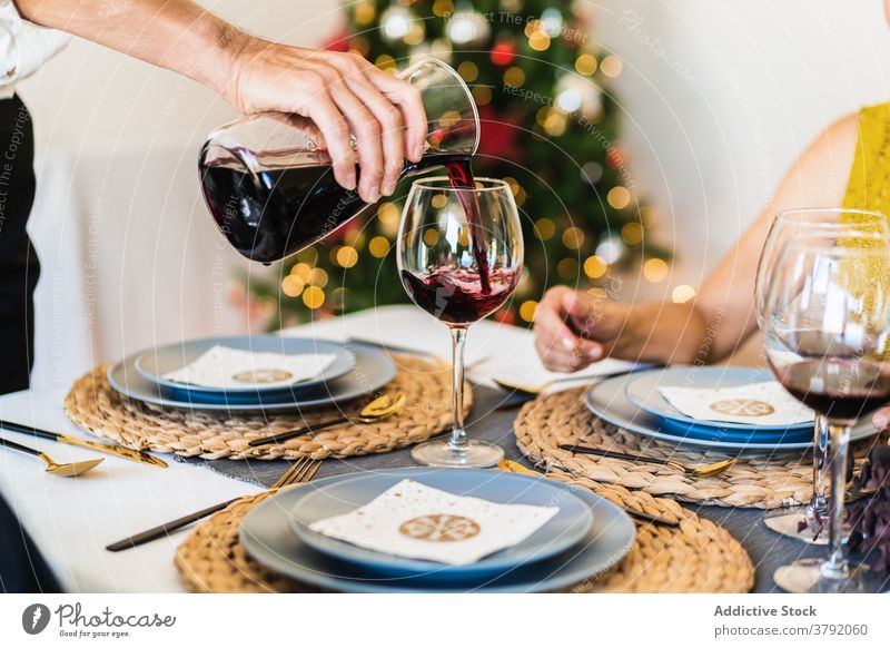 Man serving wine on Christmas eve xmas cheers wineglass christmas toast faceless celebrate gather crop view friend cheerful festive alcohol positive winter