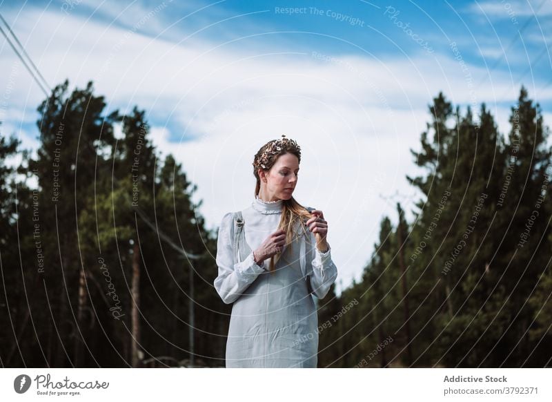 Positive woman touching hair against evergreen forest calm positive touch hair charming gentle nature gorgeous romantic tender tranquil serene elegant trendy