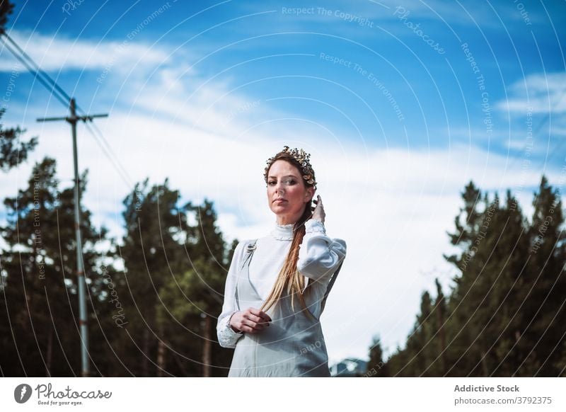 Positive woman touching hair against evergreen forest calm positive touch hair charming gentle nature gorgeous romantic tender tranquil serene elegant trendy