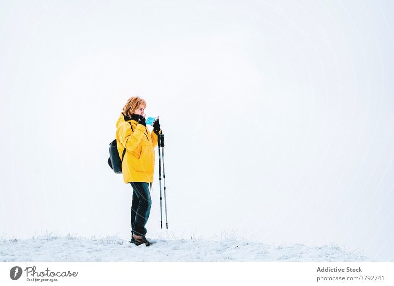 Hiker with protective mask standing on snowy terrain hiker trekking traveler coronavirus active mountain backpack adventure covid19 covid 19 pandemic freedom