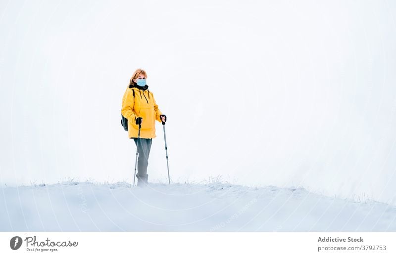 Active traveler in warm wear and medical mask in snowy mountains hiker trekking covid19 coronavirus active adventure female covid 19 pandemic freedom nature