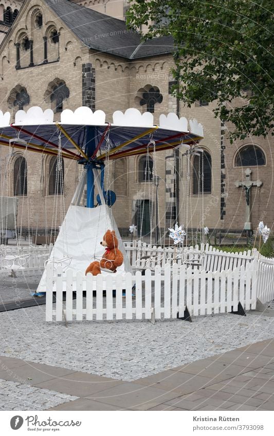 teddy bear sits in the otherwise empty children's chain carousel Carousel Merry-go-round Chairoplane Teddy bear Lonely by oneself Placeholder Empty nobody Wait