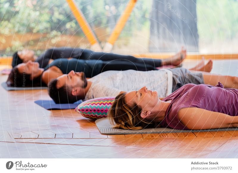 People in Shavasana pose on yoga mats people shavasana relax eyes closed meditate zen peaceful harmony class lying floor reflective together spirit