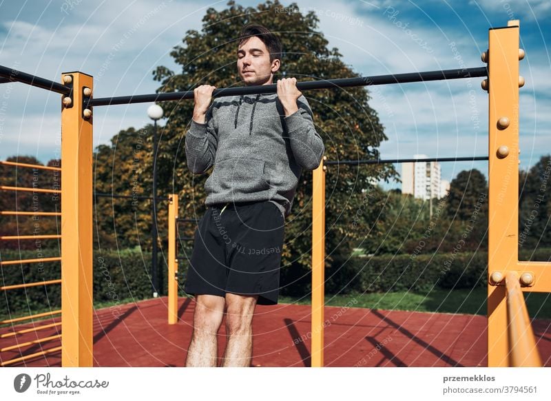 Young man doing pull-ups during his workout in a modern calisthenics street workout park care caucasian health lifestyle male one outdoors person sport teenager