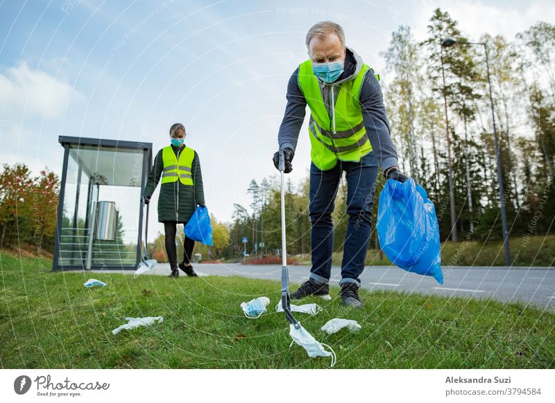 Coronavirus garbage. Volunteers collecting used disposable medical masks and gloves near the bus stop and along the highway. The problem of environmental pollution during a pandemic COVID-19