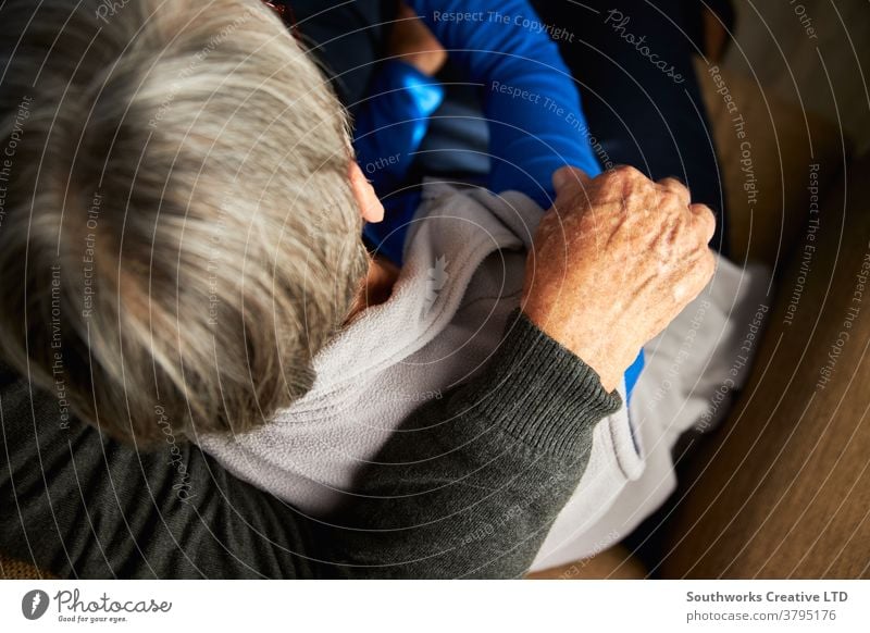 Close Up Rear View Of Loving Senior Couple At Home Hugging On Sofa Together couple senior seniors at home loving hugging affection affectionate retired