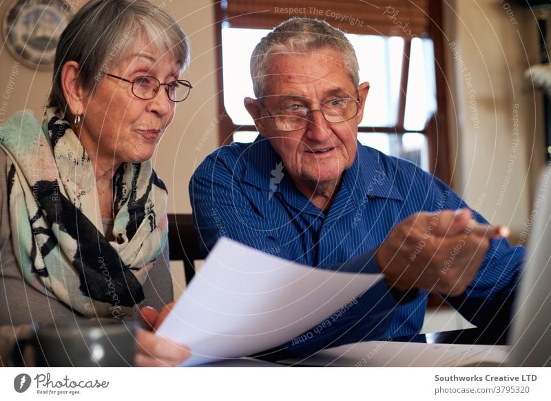 Senior Couple At Home Checking Personal Finances On Laptop couple senior seniors retired at home laptop computer online connected the internet tech shopping