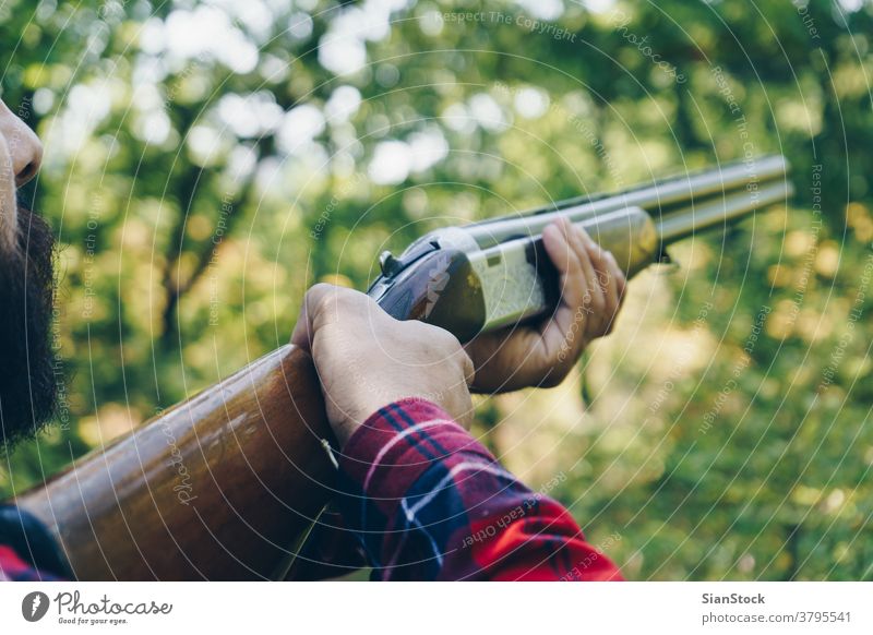 Hunter with a gun  on the forest hunting man wood young plaid shirts hands nature background hunter autumn wild bearded brutal dark men hipster guerrilla adult