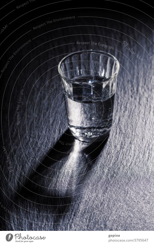 A glass of water with shadow Glass drinking glass Water Drinking water Mineral water Food food products Healthy Thirst Simple Dark darkness Sparse Shadow