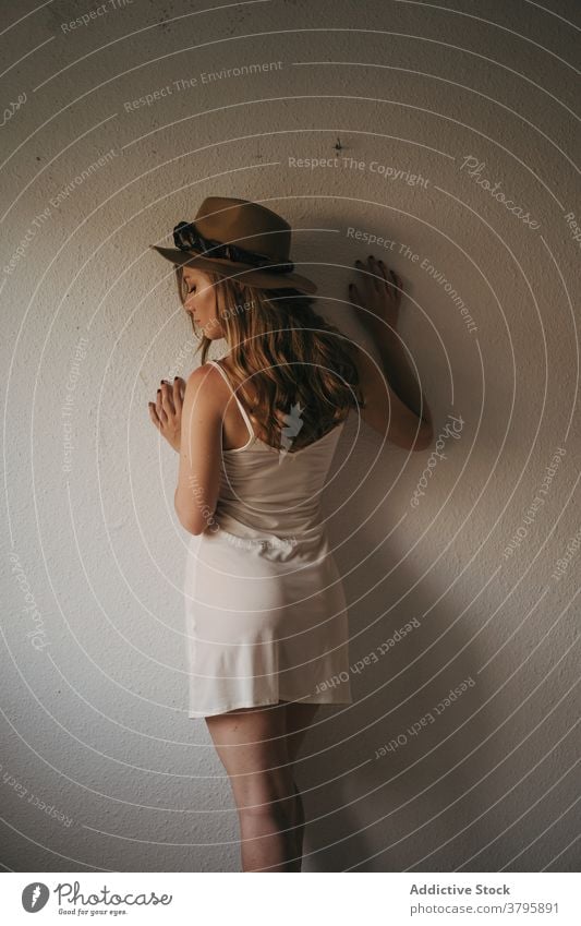 Stylish sensual woman near wall stylish appearance dreamy feminine sensitive straw hat model wistful style seductive slender home apparel trendy boho modern