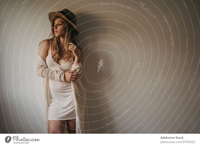 Stylish sensual woman near wall stylish appearance dreamy feminine sensitive straw hat model wistful style seductive slender home apparel trendy boho modern