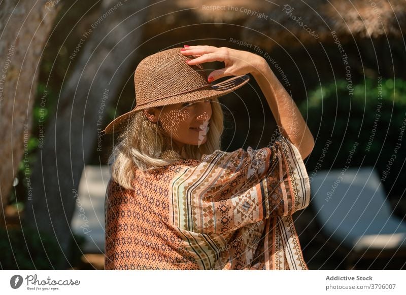 Serene traveler resting in sunlight against blue sky woman resort tourist blond vacation idyllic freedom harmony looking at camera female summer relax peaceful