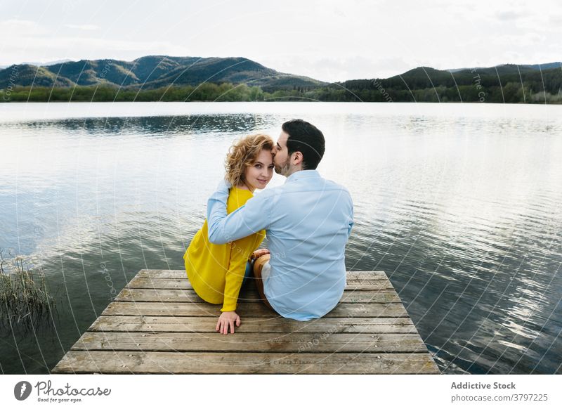 Content couple hugging on pier in summer wooden lake embrace love tender relationship pond carefree calm girlfriend boyfriend gentle romantic affection relax