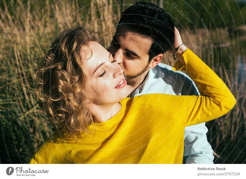 Happy couple embracing gently in nature hug love tender embrace field sunny summer relationship eyes closed girlfriend calm boyfriend together affection happy