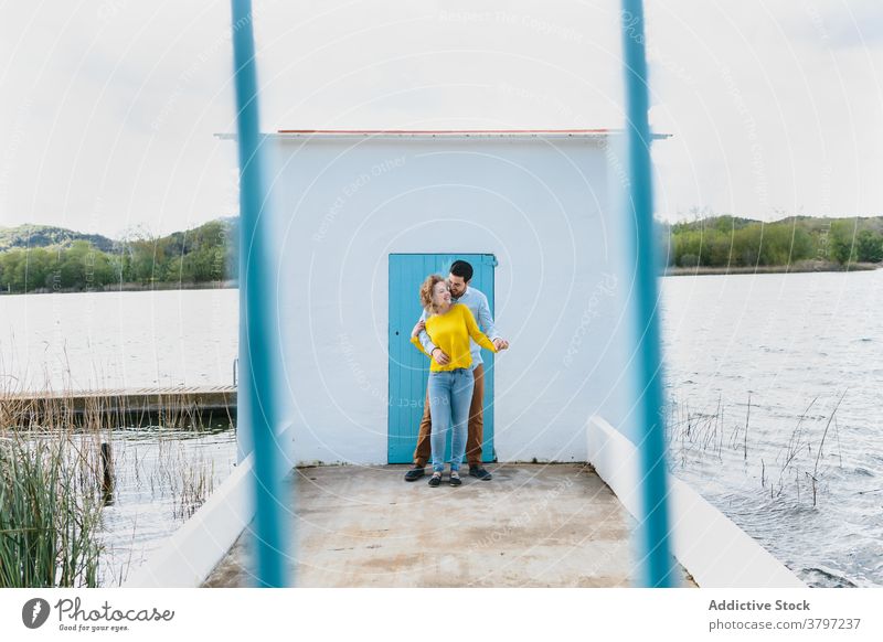 Carefree couple hugging on pier lake embrace love relationship summer quay together stroll gentle romantic water date bonding cuddle close girlfriend boyfriend