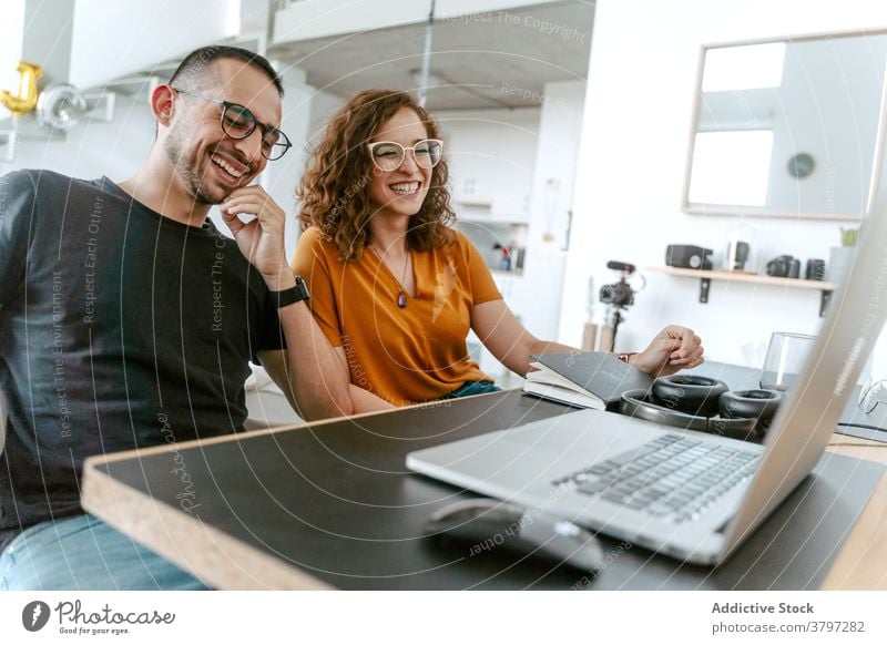 Happy couple having video conversation on laptop at home video call happy together holding hands sofa wave hand cheerful connection relationship boyfriend