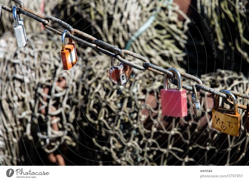 Six love - locks hanging on a chain in front of a fishing net Lock Chain Love Padlock Infatuation Together Metal Emotions Heart Rust Net Fishing net