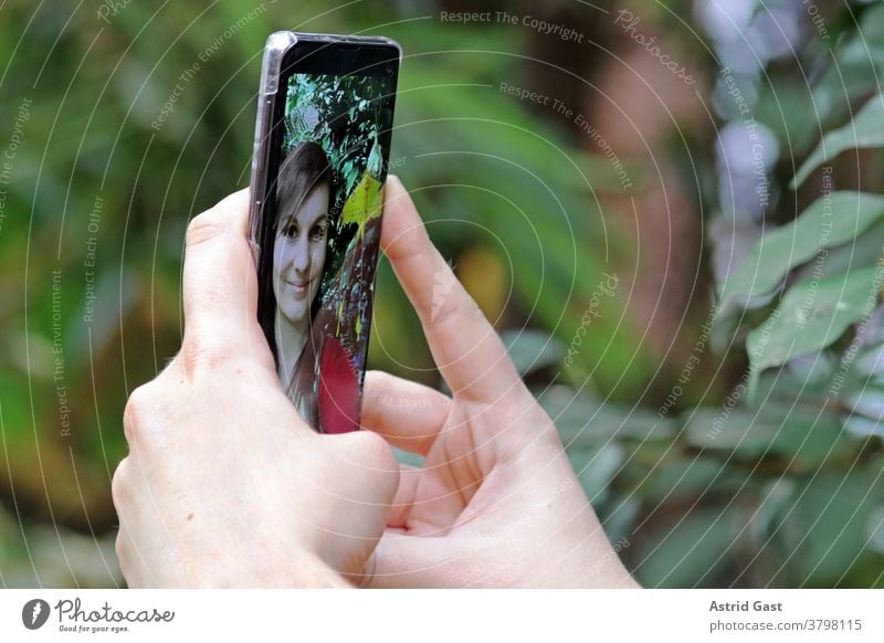 A young woman takes a self-portrait with her smartphone. A selfie with her mobile phone Woman Cellphone photo Selfie Self portrait Take a photo yourself