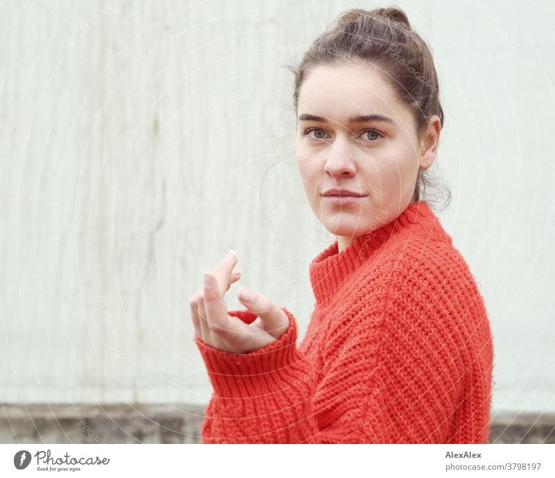 Close portrait of a young woman in front of a concrete wall Woman Young woman 18-25 years warmly pretty Charming Slim Brunette long hairs Fresh Large smart