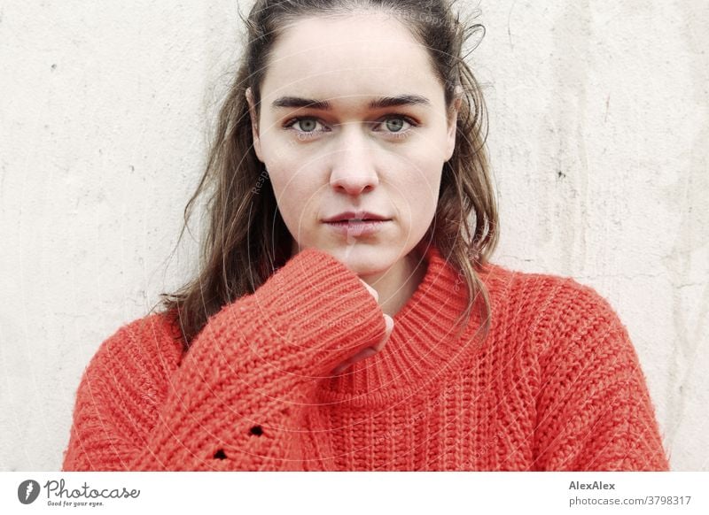 Close portrait of a young woman in front of a concrete wall Woman Young woman 18-25 years warmly pretty Charming Slim Brunette long hairs Fresh Large smart