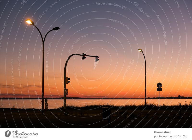 Lamps and traffic lights at the ferry by the sea at / after sunset Ocean bank coast Sky Summer Picturesque Traffic light Road sign travel Ferry vacation Tourism