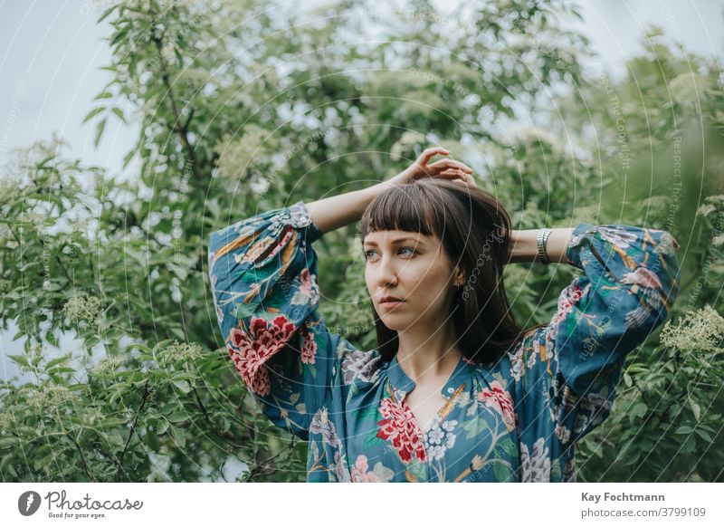 portrait of thoughtful woman fixing her hair adult attractive balance beautiful brown hair brunette cheerful confidence confident countryside daydreaming face