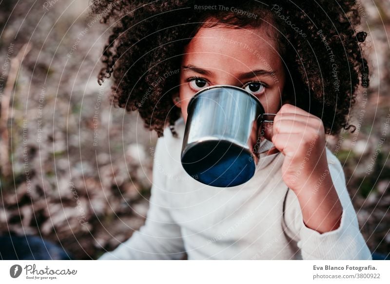 hispanic mother and afro kid girl doing picnic outdoors relaxing in nature. Autumn season. Family concept portrait daughter family mixed race motherhood