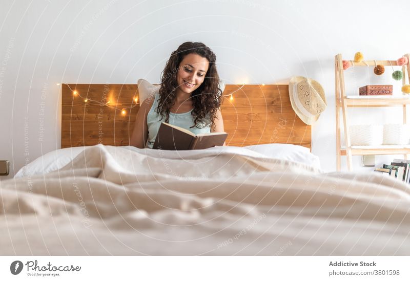 Thoughtful woman reading book in bedroom home enjoy sit literature story relax female interesting peaceful calm weekend tranquil hobby comfort serene lady flat