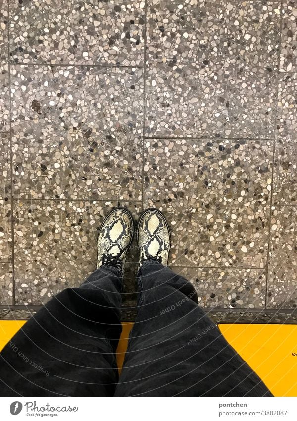 Waiting on the platform. Bird's eye view of legs and shoes in front of yellow wall Legs Footwear Fashion Platform Wall (building) Stand Human being Clothing