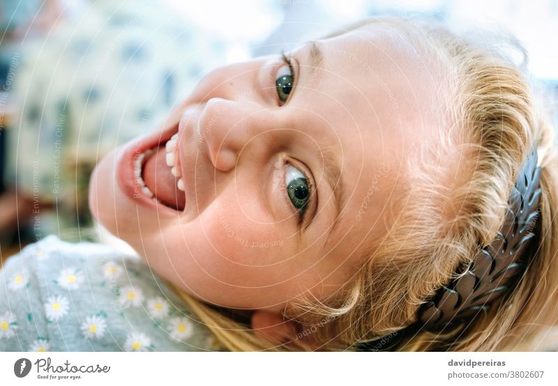 Closeup of girl looking back cheerful happy looking camera cute healthy friendly smiling open mouth female young person portrait pretty smile caucasian face