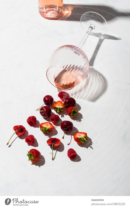 Concept composition presenting rose wine flavours of summer fruits of berries concept glass goblet flatlay berry taste shadow red alcohol bar beverage blush