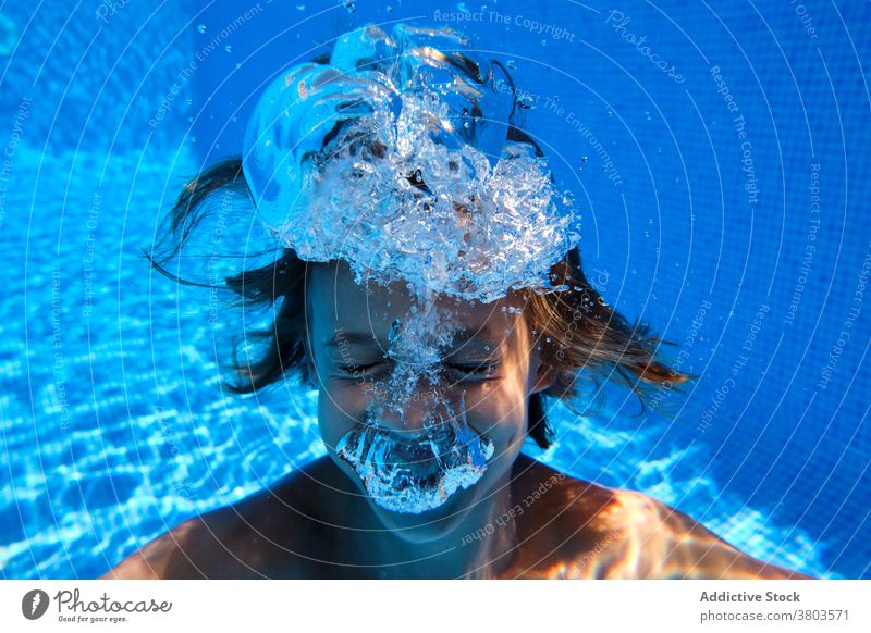 Joyful boy diving into pool water teenage dive bubble cheerful underwater activity smile fun carefree playful splash aqua active resort enjoy swim relax laugh