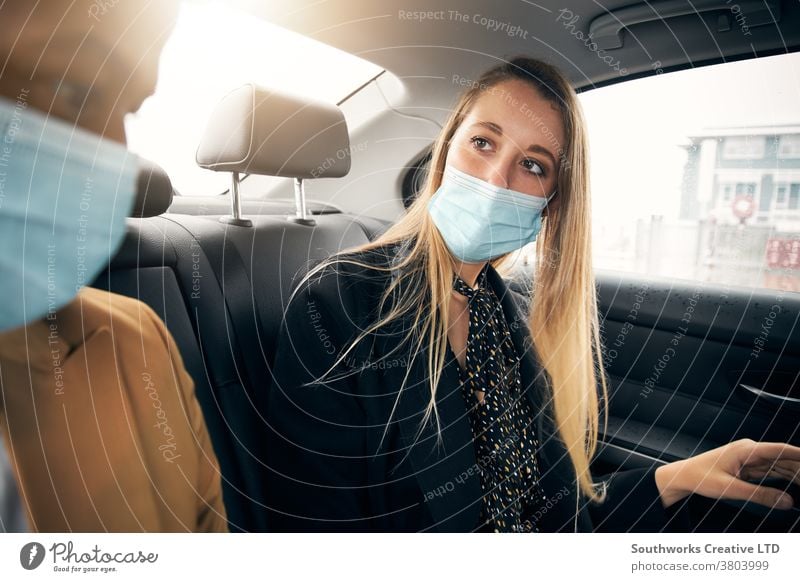 Business Couple Wearing Masks Having Conversation In Back Of Taxi During Health Pandemic business businessman businesswoman face mask face covering wearing taxi