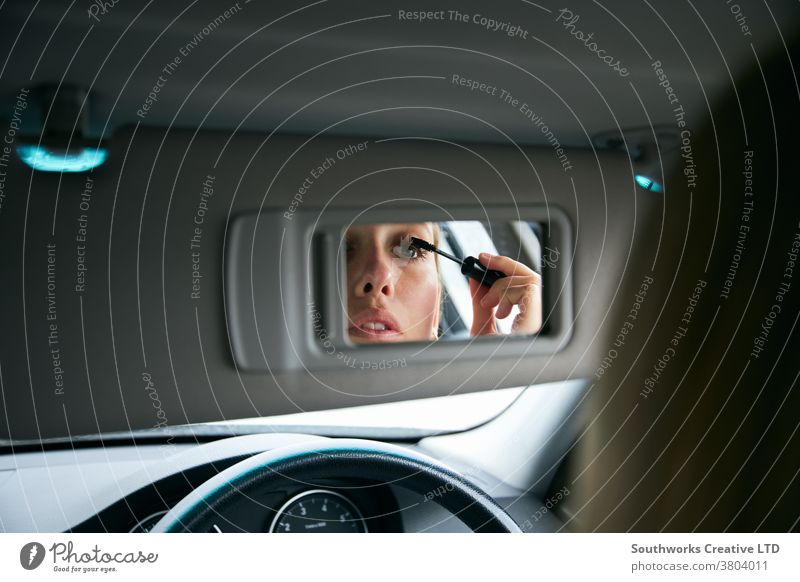 Young Businesswoman In Car Putting On Make Up Before Going Into Work In Office business businesswoman car make up putting on late for work driver driving