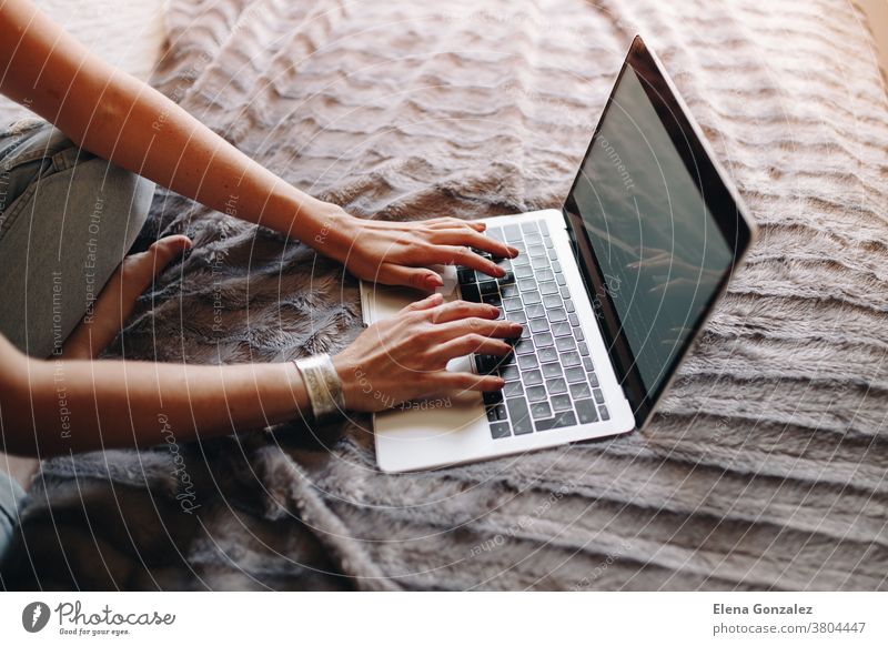 Woman's hands typing on laptop keyboard in the cozy bedroom woman working sitting macbook businesswoman using computer home female person technology lifestyle