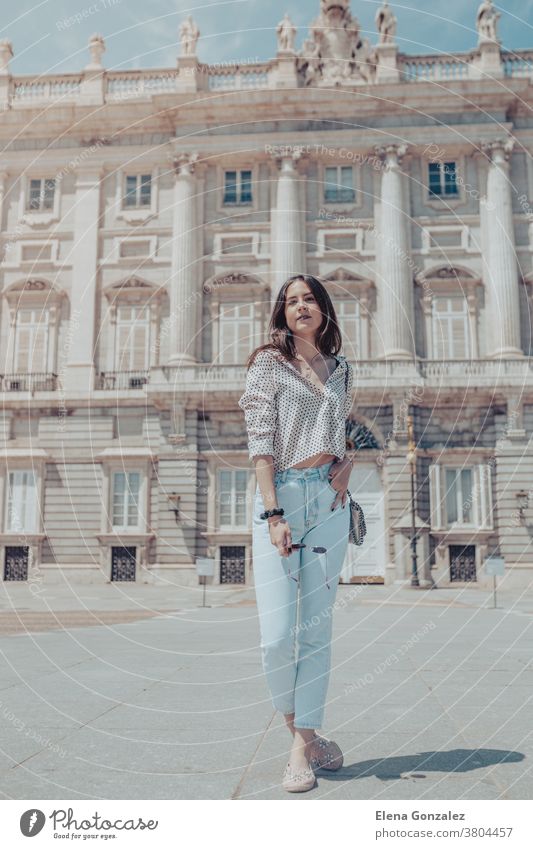 Beautiful tourist woman posing near Royal Palace of Madrid, Spain Tourist Young Woman Girl Fashion fashionable bag handbag Purse travel ancient old architecture