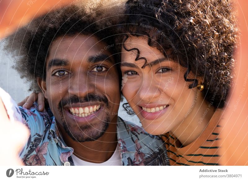 Happy young ethnic couple hugging and smiling at camera smile cuddle cheerful happy love relationship together embrace portrait enjoy affection sunny day