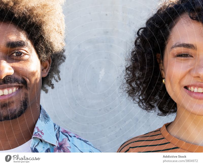 Happy young ethnic couple smiling at camera smile cuddle half face cheerful happy love relationship together portrait enjoy affection sunny day boyfriend