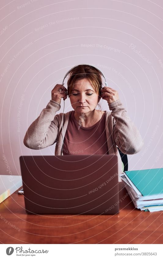 Woman working talking doing her job remotely during video chat phone call on laptop from home binder class classes computer connect connecting copy space